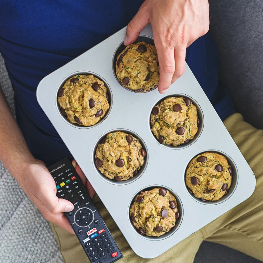 Guy eating "Stud" Zucchini Chocolate Chip Muffins on Couch