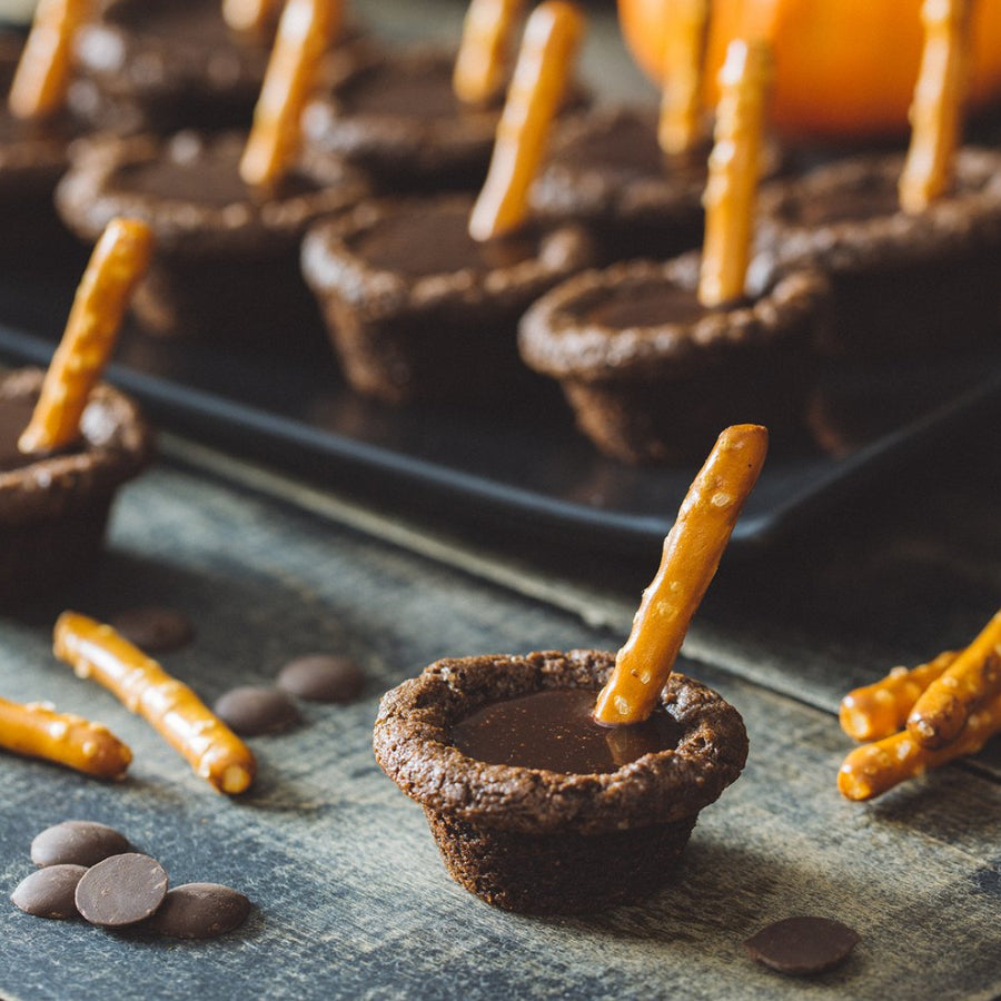 Chocolate Cookies Baked in Mini Muffin Tin with Pretzel Stick on Top to Resemble a Mini Cauldron