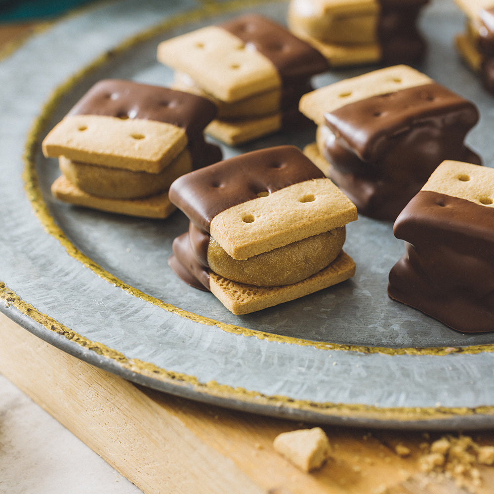 Chocolate Dipped Sun Butter Graham Sandwiches on a rustic plate