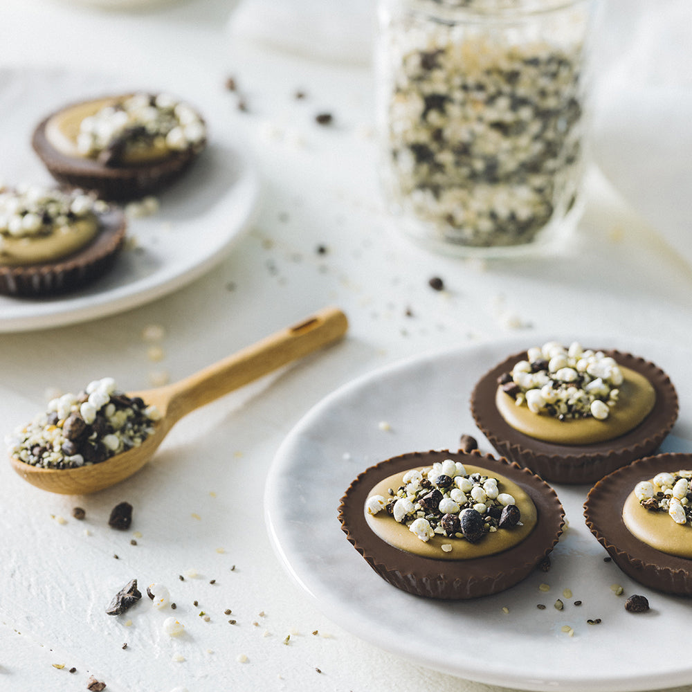 Sun Cups topped with Sunflower Butter, puffed millet, hemp seeds, chia seeds and cocoa nibs